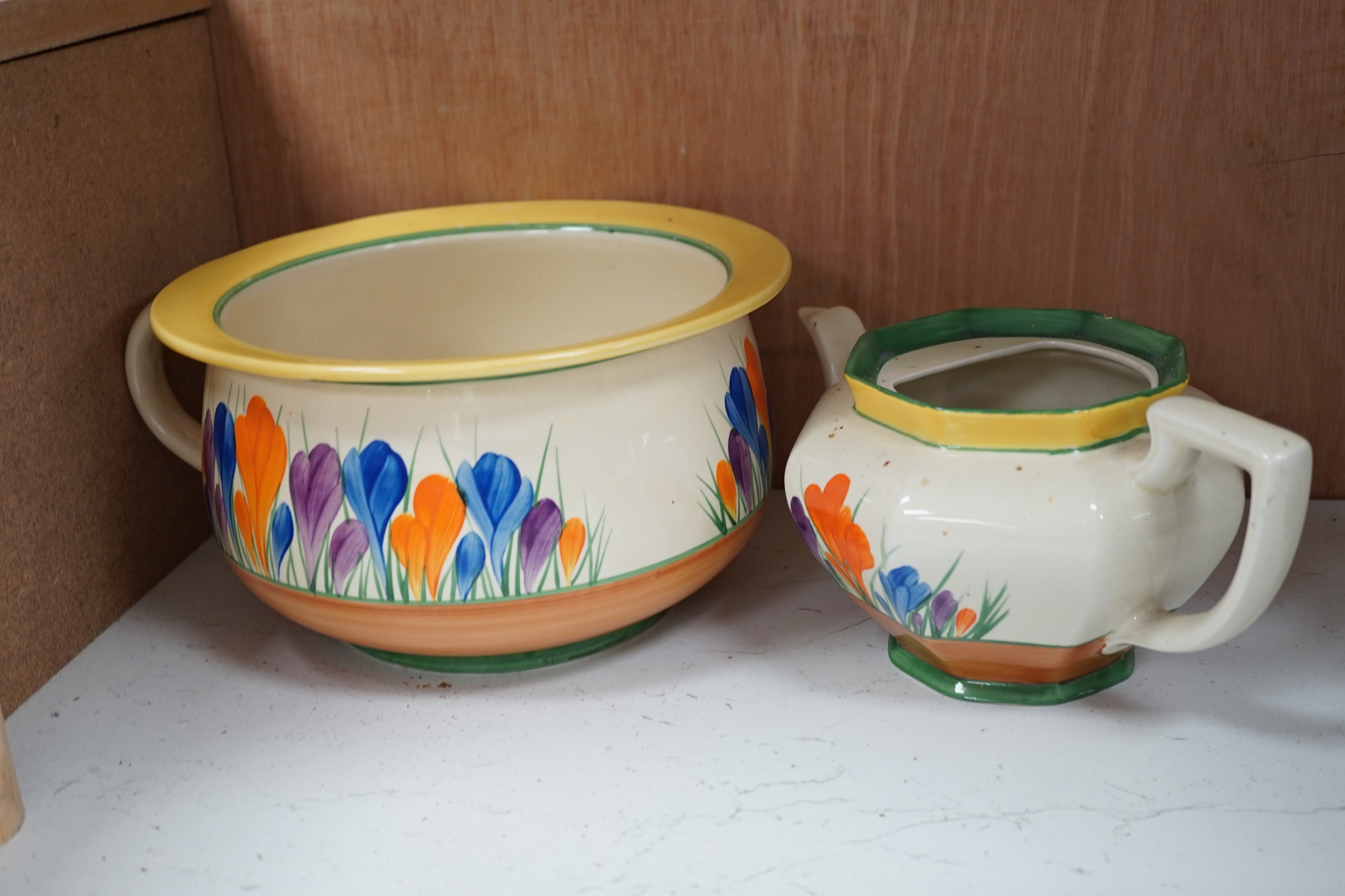 A Clarice Cliff Crocus pattern jug and basin, chamber pot and teapot with cover missing, basin 37cm diameter